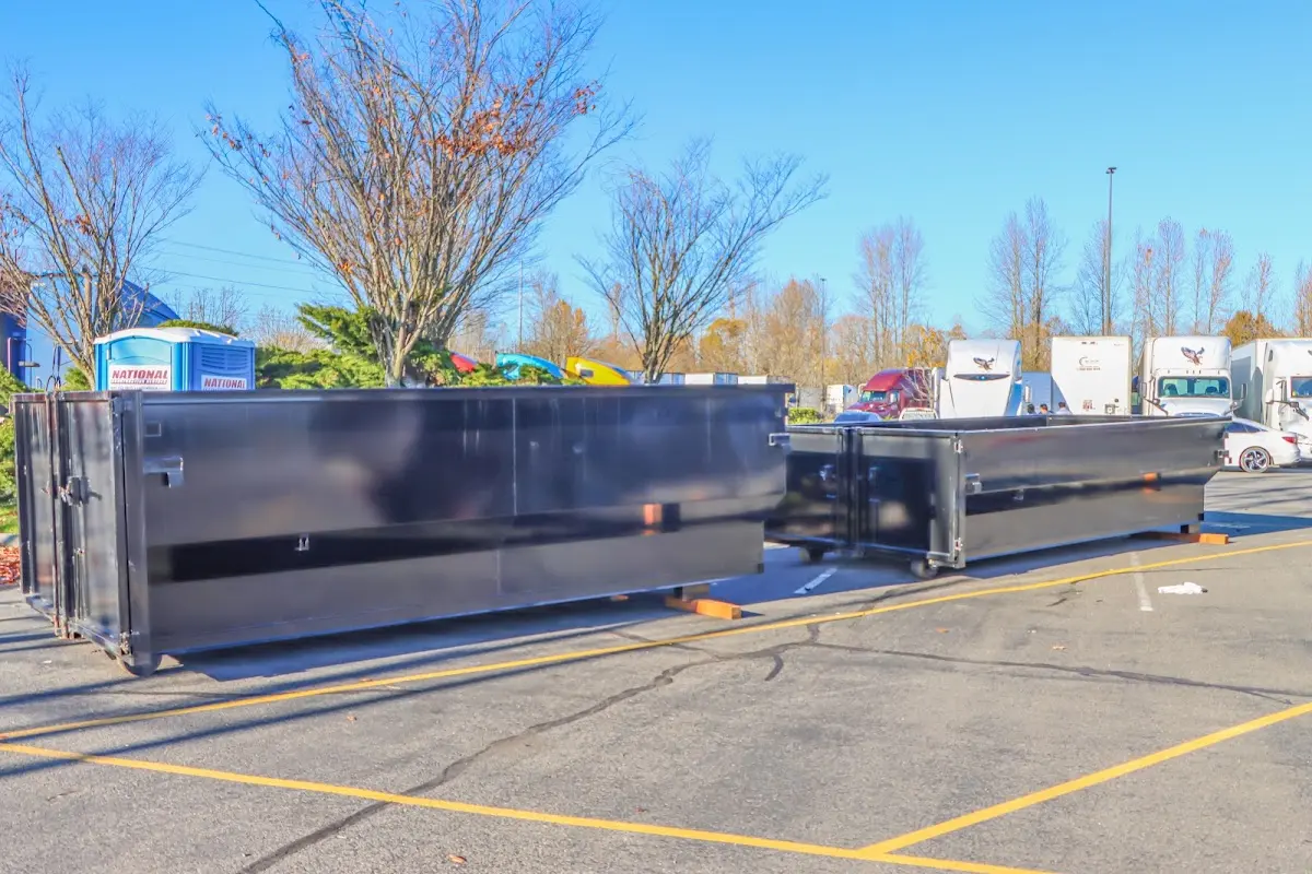 Professional dumpster rental service with roll-off container on residential driveway in Goffstown